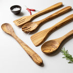 Set of wooden utensils including spoons and a spatula on a light background.