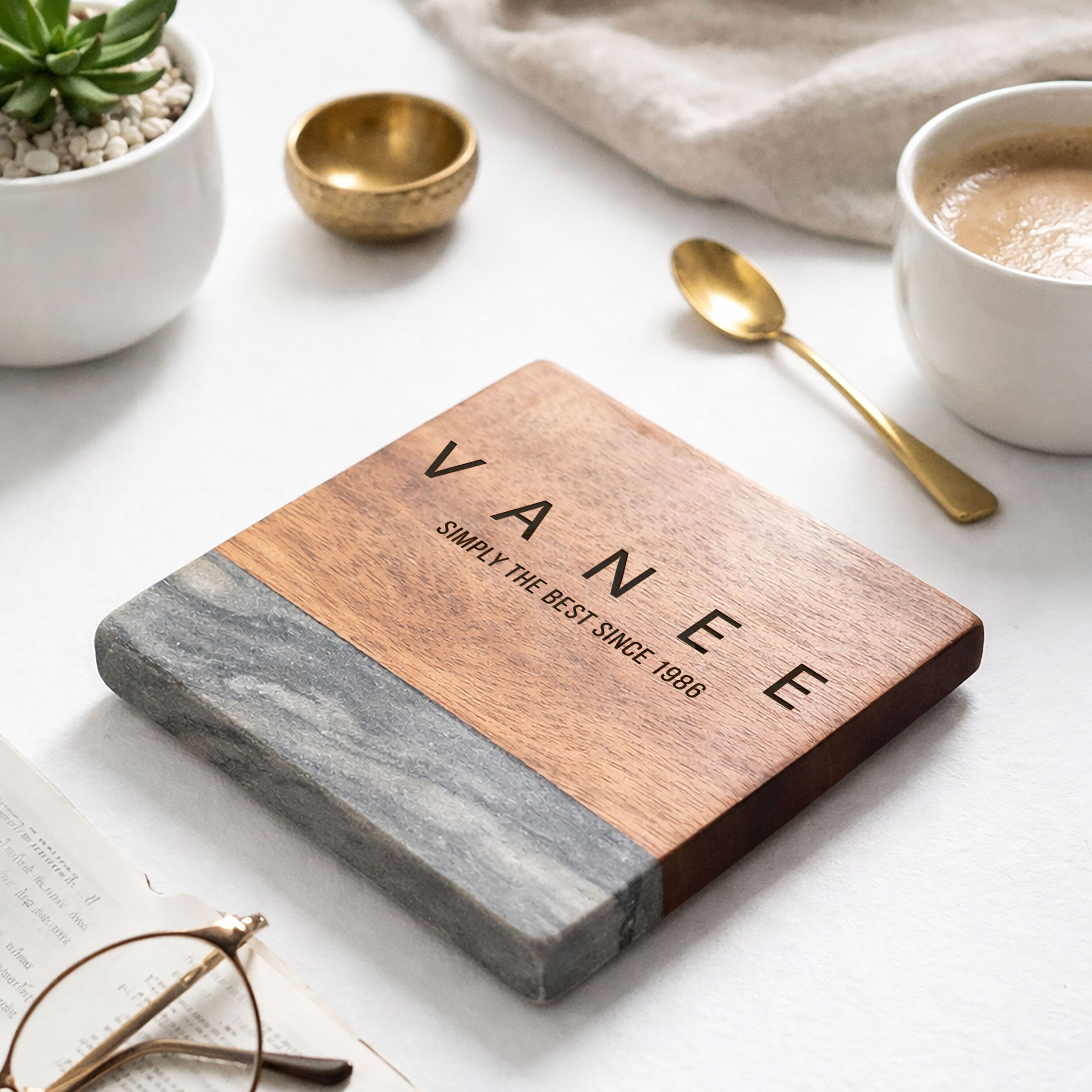 Wooden and stone cutting board with 'VANEE' branding on a white surface with kitchen items.