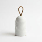 White ribbed vase with a rope handle on a light gray background