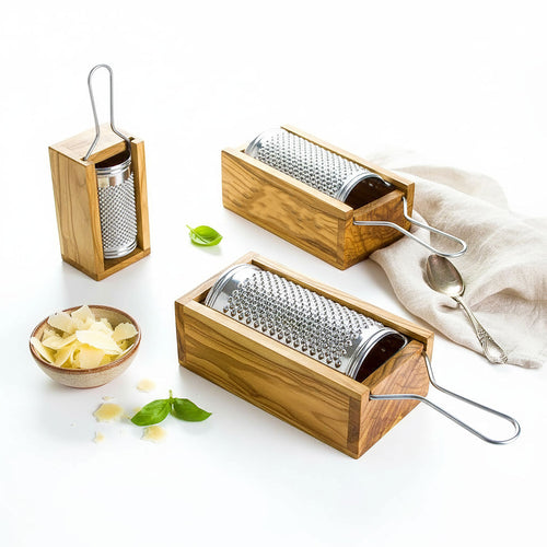 Three wooden graters with metal grating surfaces on a white surface.