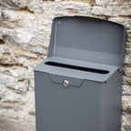 Gray mailbox against a stone wall background