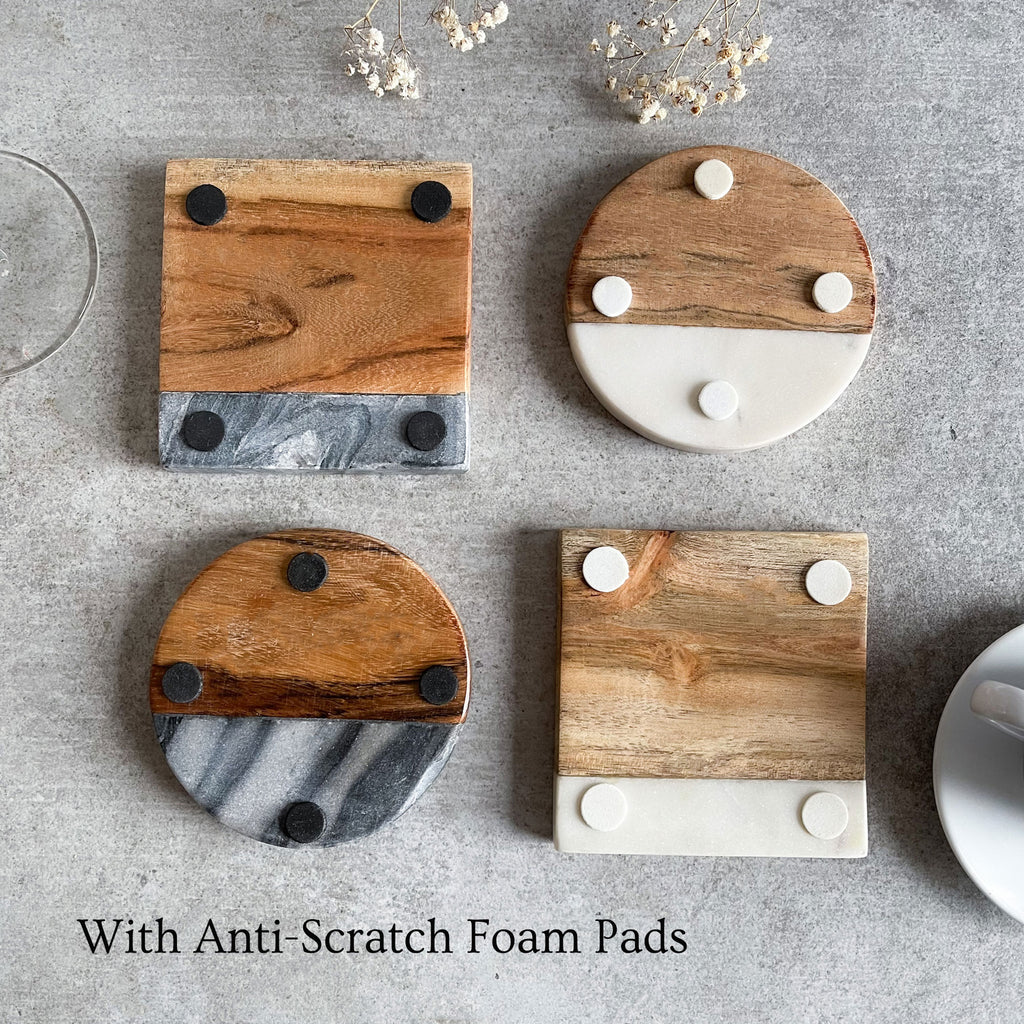 a selection of our 4 marble coasters showcasing the anti scratch foam pads these have on a grey surface with some flowers