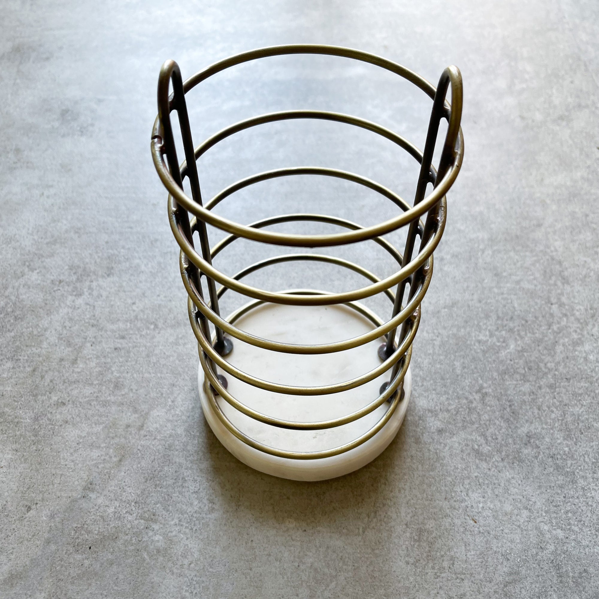 Decorative utensil  holder with metal wire design on a gray surface