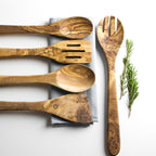 Set of wooden utensils including spoons and a spatula on a light background.