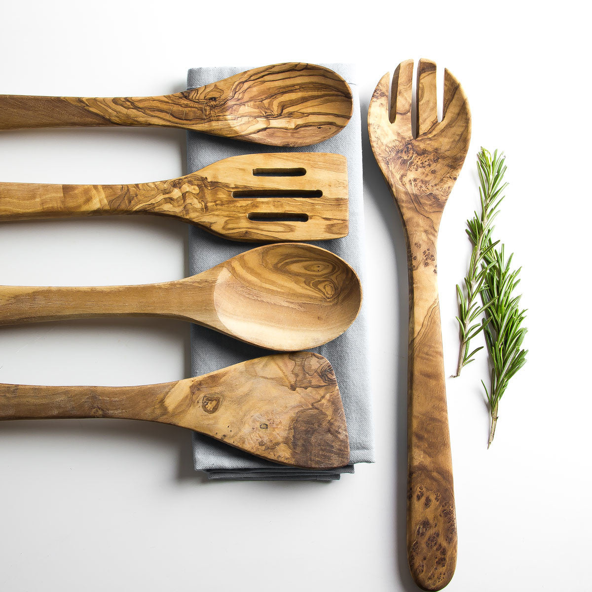 Set of wooden utensils including spoons and a spatula on a light background.