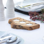 a 3 tealight holder made of olive wood with rustic bark on a white surface with wedding decor