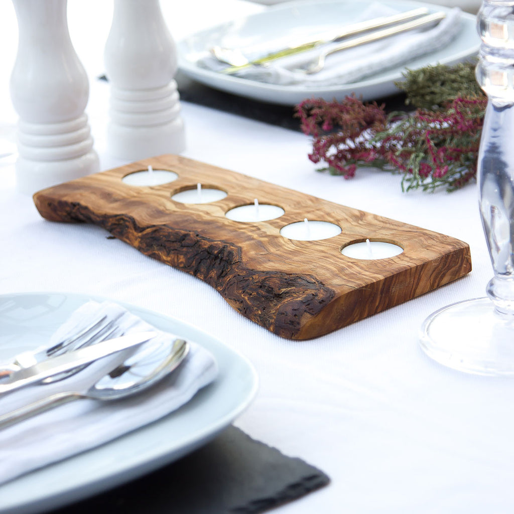 a 5 tealight holder made of olive wood with rustic bark on a white surface with wedding decor